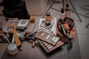 Olika kosmetiska produkter och verktyg för fransförlängning och makeup på ett bord.
