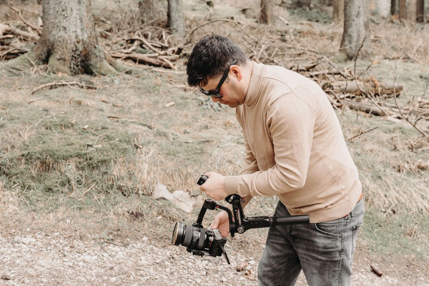 Filmskapare justerar en videokamera under inspelning i skogen